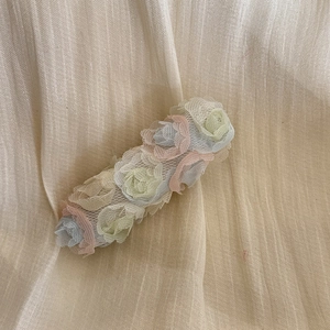 Dettaglio molletta per capelli con fiori in chiffon 3D e petali di rete color pastello