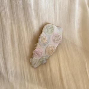 Dettaglio di fiori di rosa in garza colorata su un fermaglio per capelli floreale dolce