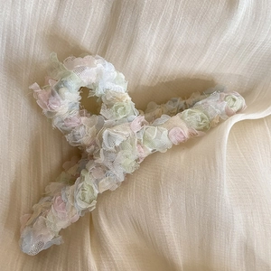 Pinza per capelli in chiffon con motivi floreali in rete su sfondo di tessuto beige