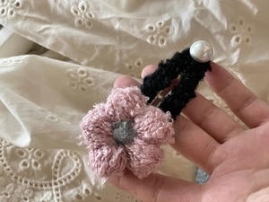Detalle de pinza para el pelo con flor rosa de ganchillo hecha a mano con detalle de perla