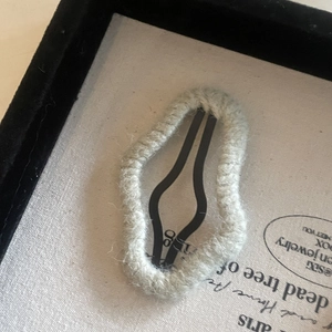 Knitted fabric cloud hair clip in morandi grey-green on a jewelry display card