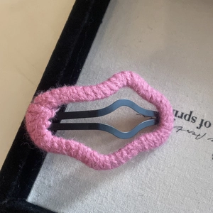 Close-up of pink knitted wavy edge hair clip with a minimalist handmade aesthetic style