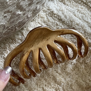 Detail view of large tortoiseshell resin hair claw clip with glossy mahogany wood texture