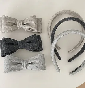Close-up of handmade gray plaid bow hair clips and headbands with textured fabric detail
