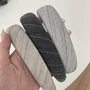 Detail view of thick padded headbands with elegant herringbone weave in three neutral colors