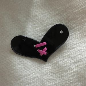 Detail einer süßen herzförmigen Haarspange mit rosa Bändchenwebung und kleinem Strassstein