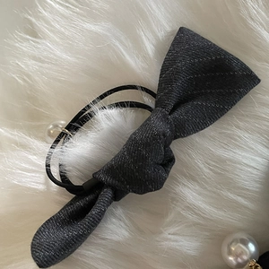 Detail of dark grey plaid scrunchie with silver threads and elegant white pearl decor