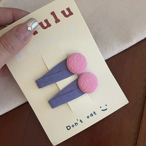 Pink and purple fabric covered oval hair clips for girls set on a display card