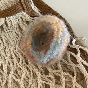 Detailed close-up of fluffy mohair hair tie with orange and grey gradient ombre textures