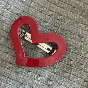 Detailed 45-degree view of a red heart spring hair clip with a glossy finish