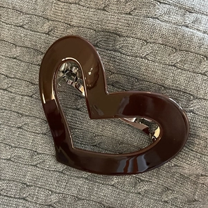 Detail of a large chocolate brown heart-shaped spring hair clip with metal base