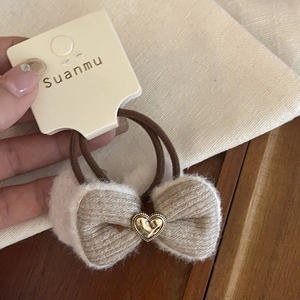 Coletero de lazo de felpa beige con borde de piel blanca y detalle de corazón dorado