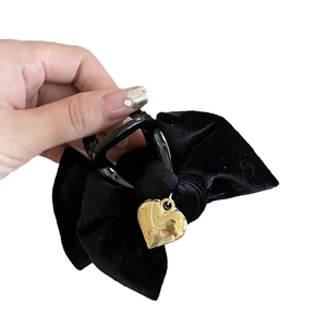 Elegant black velvet bow hair claw clip with a hanging gold heart pendant