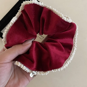 Elegant burgundy velvet hair scrunchie with white pearl trim and silver logo charm