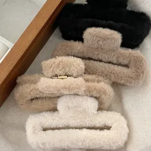 Close-up of four plush faux fur hair claws in coffee tones with gold metal springs