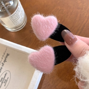 Sweet pink plush heart-shaped hair clips with fuzzy texture for a cute hairstyle