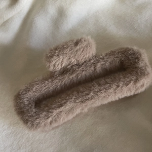 Close-up of a large coffee-colored plush hair claw clip with a soft faux fur texture