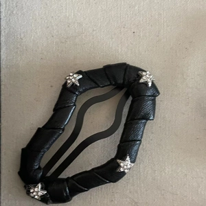 Detail showing stars rhinestones on black leather hair clip and wavy metal grip