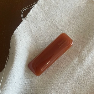 Detail of red-brown acetate hair clip with golden Barrette La France lettering