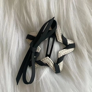 Star-shaped hair clip with black ribbon and white faux leather woven design