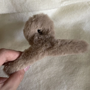 Vue détaillée de la texture pelucheuse marron et de la grande pince à cheveux pour chignons