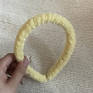 Détail d'un serre-tête en peluche jaune doux avec texture moelleuse pour l'automne hiver
