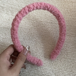Détail du serre-tête rose en fausse fourrure douce avec texture moelleuse de laine d'agneau