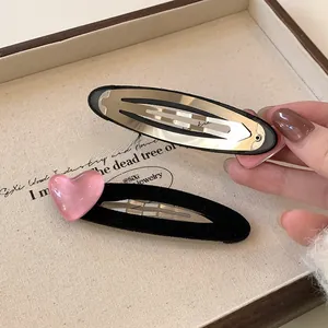 Detailed front and back view of velvet heart BB hair clips on a wooden tray
