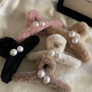 Détail de pinces à cheveux en peluche avec perles en noir, rose, beige et nuances de café