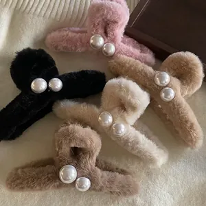 Pinces à cheveux en peluche avec perles en rose, noir et beige sur fond blanc moelleux