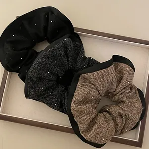 Dettaglio di elastici per capelli in tweed luccicante con cristalli e bordo in raso