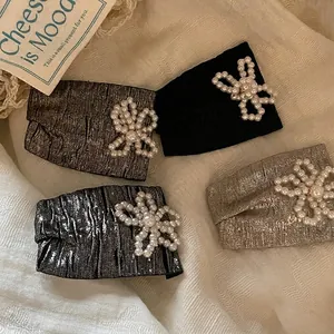 Elegant four-piece floral pearl hair clip set with metallic shimmer fabric texture