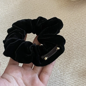 Detail of grey velvet scrunchie featuring elegant gold beads and soft pleated texture
