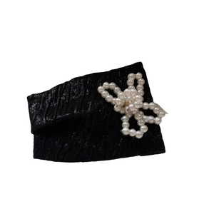 Elegant black pleated headband featuring a delicate white faux pearl bow decoration