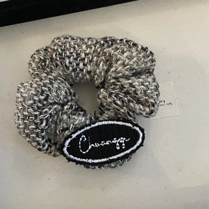 Knitted tweed scrunchie with black white grey textured fabric and decorative patch