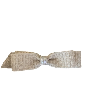 Elegant cream tweed bow hair clip with a large pearl center for women's hairstyling