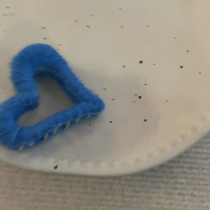 Detailed view of heart-shaped blue knit hair claw clip with cozy winter texture