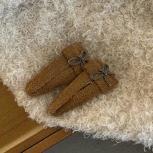Gros plan de barrettes à cheveux en peluche marron avec nœuds noirs et texture douce