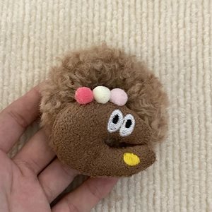Süßes braunes Plüsch-Haargummi mit Cartoon-Augen und bunten flauschigen Pompons-Detail