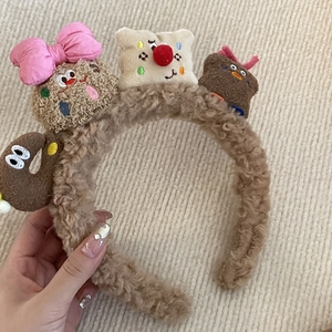 Detailansicht eines Plüsch-Stirnbandes mit süßen Bären- und Toast-Cartoon-Figuren in Braun
