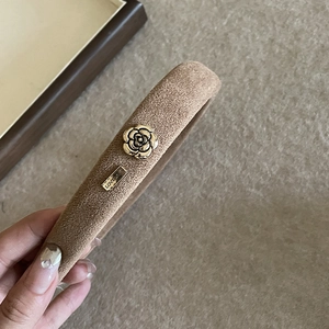 Brown velvet padded headband with gold rose accent and metal logo for women