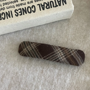 Detailed view of a brown plaid BB hair clip with vintage Scottish fabric texture
