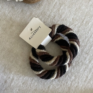 Close-up of thick spiral braided hair ties in black and beige with high elasticity