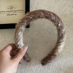 Close-up of the thick twisted wool texture on the brown and beige winter headband