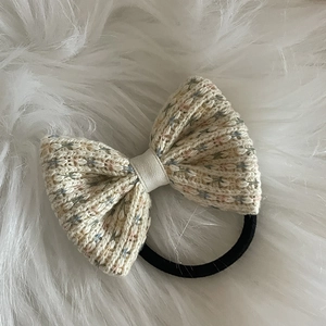 Chouchou noeud en tricot crème avec pois colorés sur fond de fausse fourrure blanche
