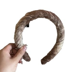 Brown wool padded headband with twisted weave texture and retro knit design on white background