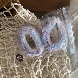 Détail de chouchous en mohair faits main en mélange violet et bleu avec étiquette artisanale
