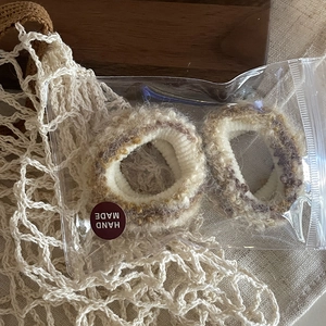 Détail de chouchous en mohair duveteux avec emballage fait main sur fond en tricot