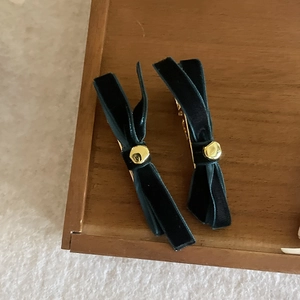 French style black velvet bow hair clips with gold beads on a wooden tray