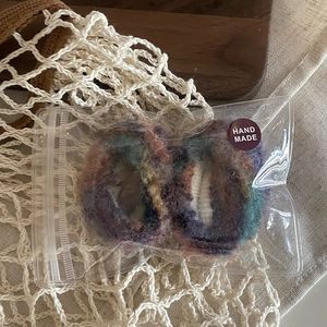 Vue détaillée d'un chouchou en mohair fait main dans un emballage transparent avec étiquette